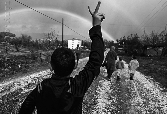 Hassan Saad, 13, who fled Idlib in Syria, flashes a victory sign while walking outside the refugees camp near the Turkish-Syrian border in the southeastern city of Yayladagi